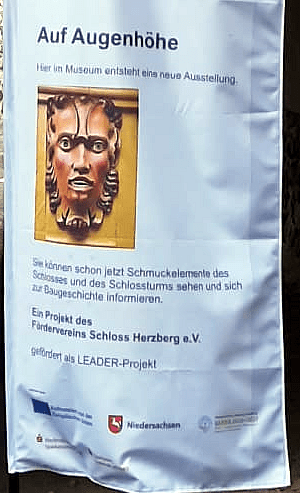 Auschnitt von: Vertikales Banner vor dem Museum Schloss Herzberg mit Hinweis auf die entstehende Ausstellung „Auf Augenhöhe“,