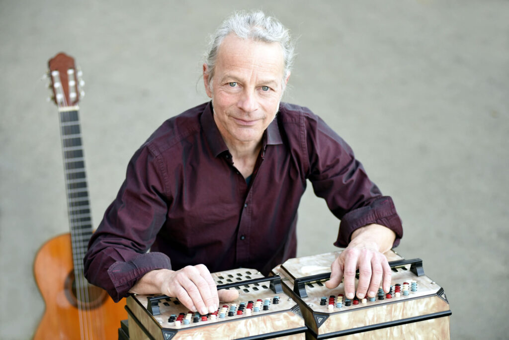 Musiker Oliver Jaeger mit Gitarre und Symphonetta – Szene aus dem Schlosskonzert ‚Sternenklang über dem Atlantik‘ mit iberisch-lateinamerikanischer Klangpoesie.